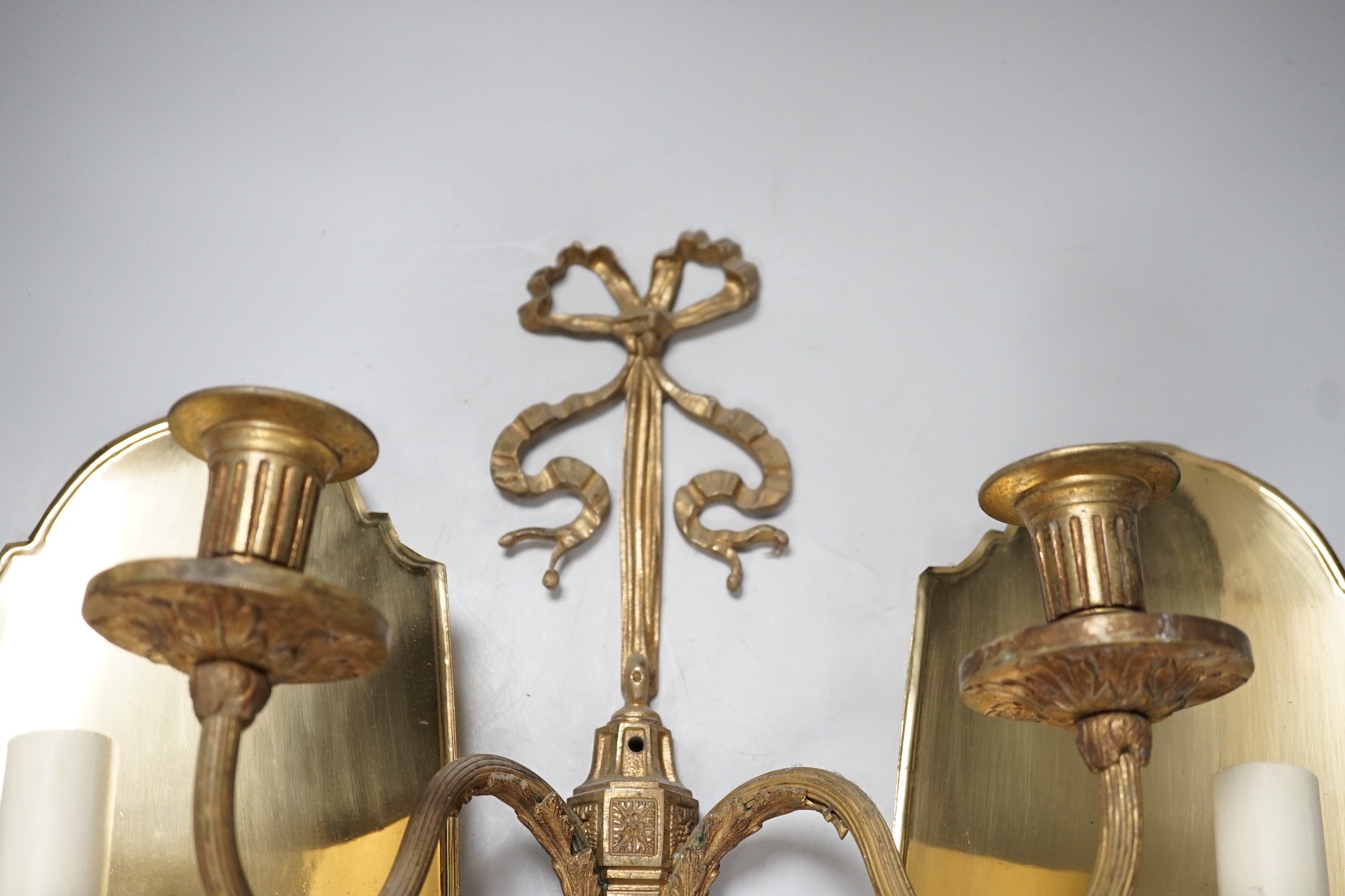 An 18th century style ribbon design brass two branch wall sconces and a pair of Dutch style brass wall lights, tallest 44cms high